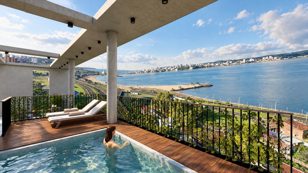 Solarium junto a la piscina, con reposeras y vista al río Paraná y a la costanera