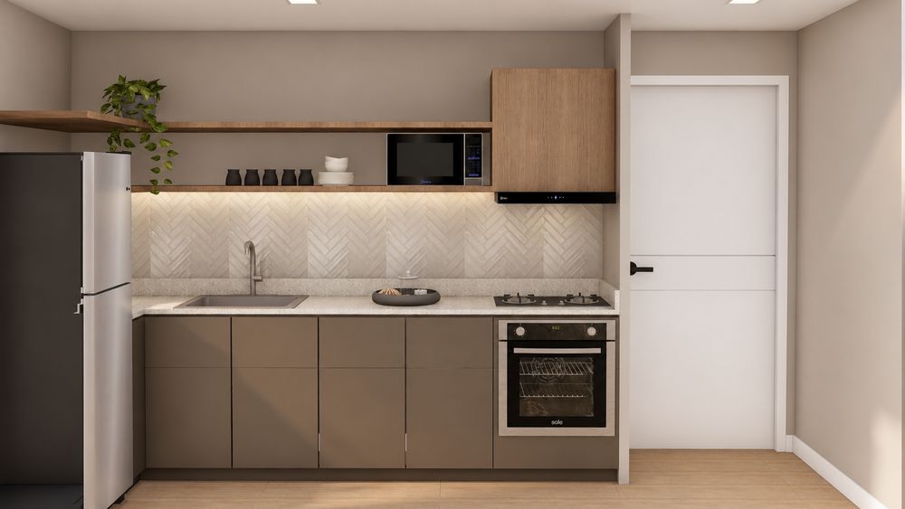 Cocina del departamento con muebles en tonos cálidos, mesada y horno