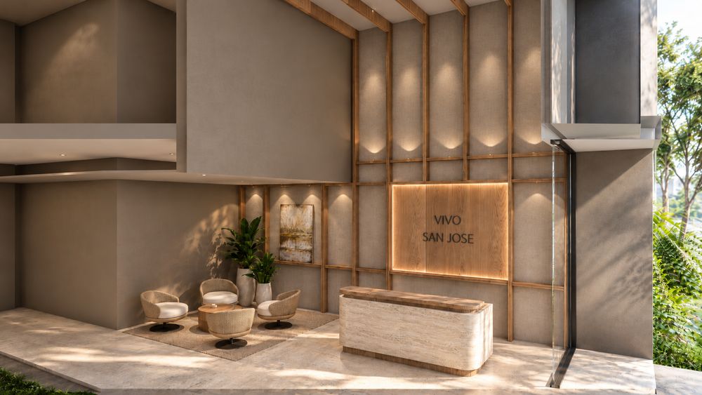 Lobby de doble altura con recepción revestida en piedra y sala de espera